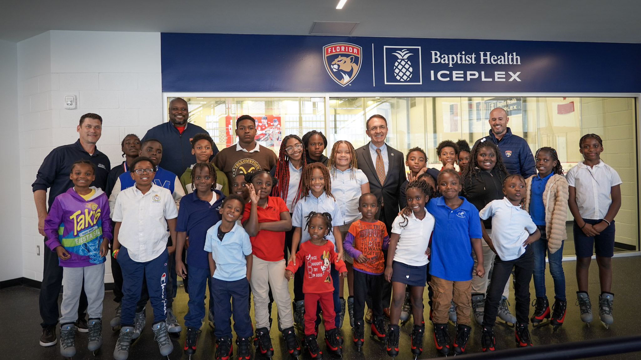 Mayor Trantalis in a group shot in front a Florida Panthers logo